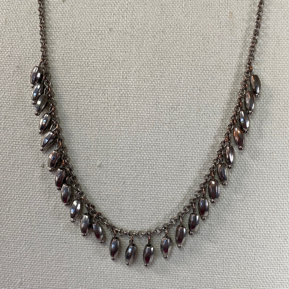 Long silvertone necklace with small dangles along the chain
